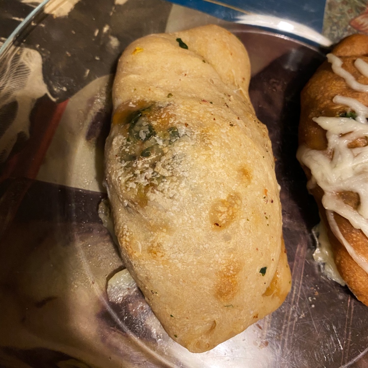 an uncut calzone on a glass plate