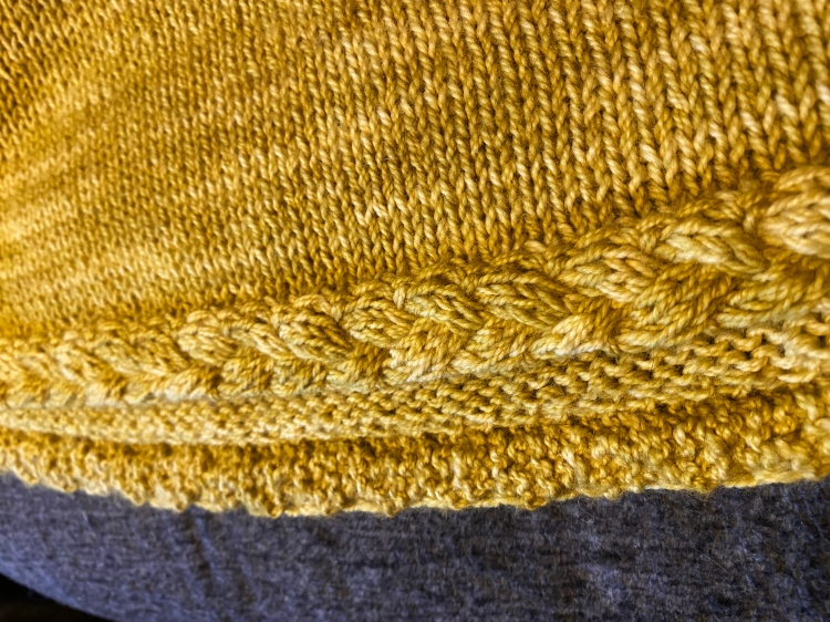 closeup of bottom edging on sweater laying flat
